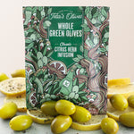 Close up of Teta's Olives Whole Green Olive Snacks, Citrus Herb Infusion flavor with olives and lemon slices surrounding the bag