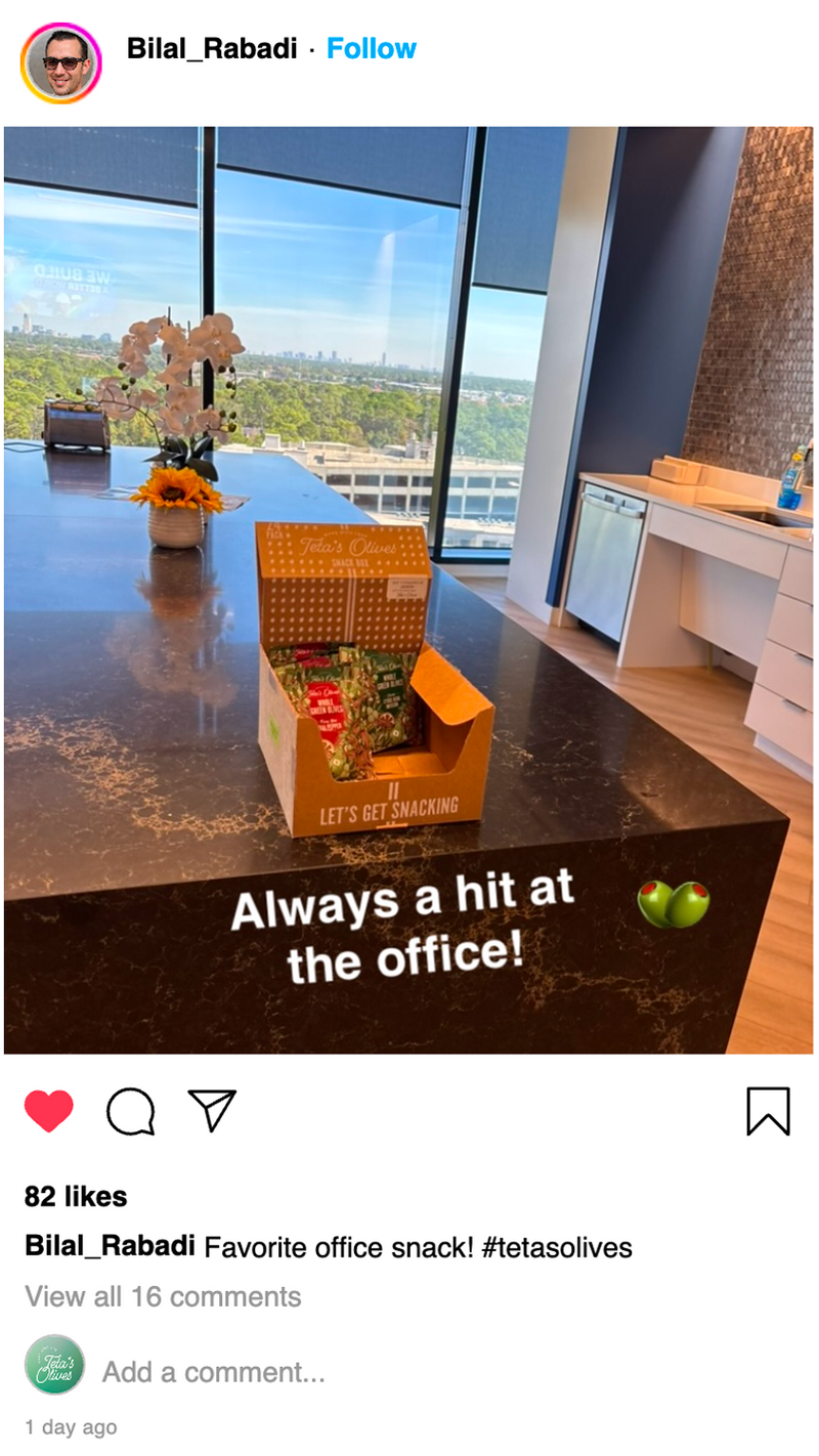 Office snack box on a desk with a view of a cityscape through large windows.
