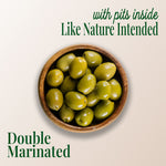 image of a plate of whole green olives, with text saying "with pits inside like nature intended" and "double marinated" with teta's olives logo
