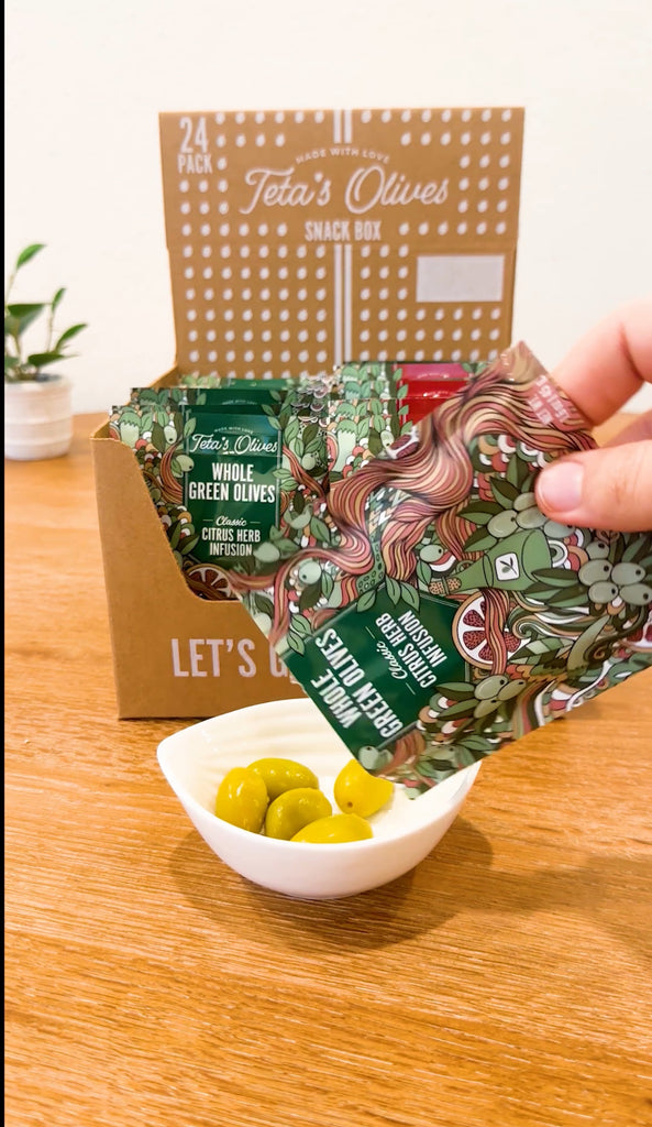Unboxing video of 24 pack variety box. Bag is torn open revealing vibrant cracked green olives. 