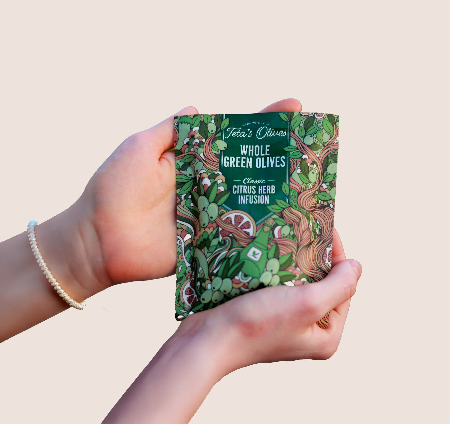 teta's olives, close up, classic citrus herb infusion snack bag, in hands against a nature background